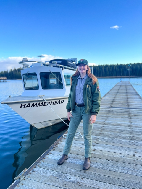 Woman standing by boat on lake 