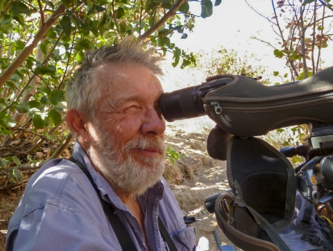 A man looking through a spotting scope