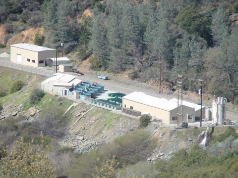 Overhead shot of Livingston Stone National Fish Hatchery. Photo includes tan buildings and large green circular and rectangular tanks. 