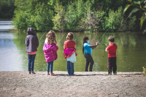 woman in a mask teaching youth how to fish