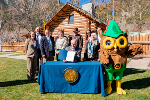 A group of people standing behind Nevada governor Steve Sisolak during a document signing event