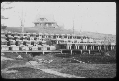 Black and white image of large wodden boxes on the side of a hill