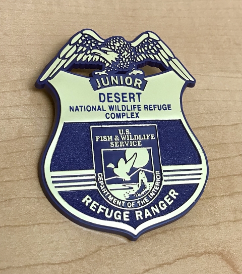 Blue and gold badge depicting the FWS logo and Junior Refuge Ranger