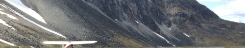 The side of a mountain and small airplane.