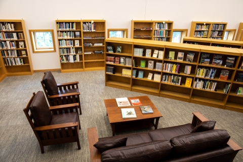 Room with sitting area and bookshelves full of books