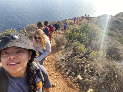 A woman taking a selfie with a line of hikers behind her