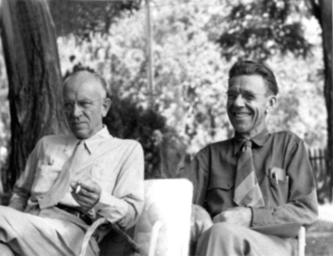 Two men sitting in chairs outdoors