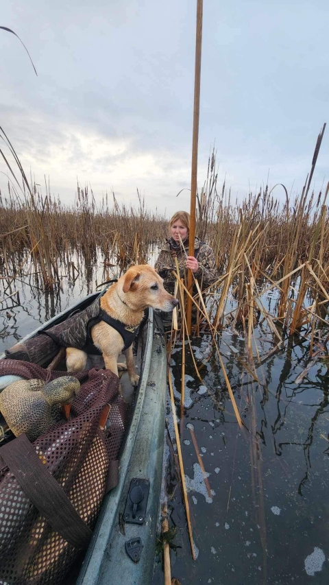 Sarah Fleming with her dog Jager on a boat at the Dury Site in New York