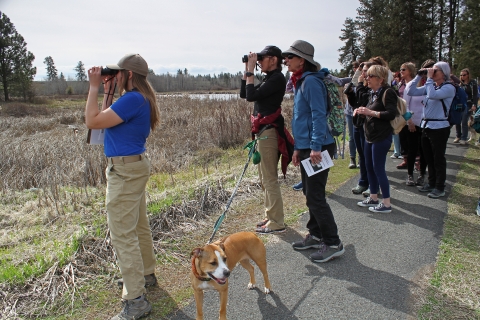 A FWS intern leads a group of women on a guided bird walk