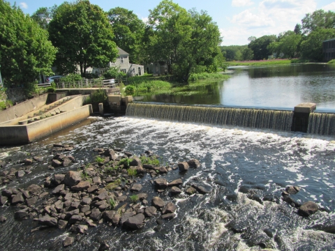 A river flowing over a dam, creating a cascading waterfall effect.