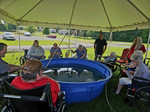 Elderly people fishing out of blue tub