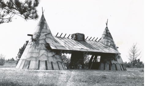 Black and white image of a stone masonry and faux teepee structure