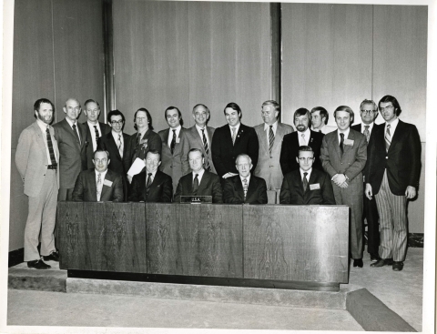 group of men in suits pose for photo