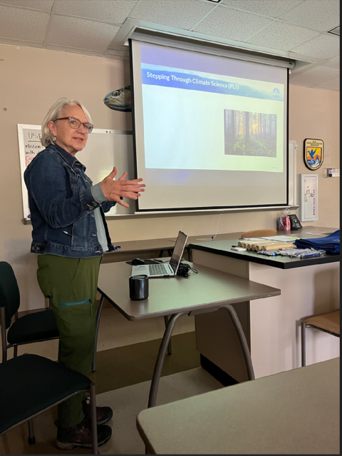 Workshop leader speaking in the front of a room to participants 