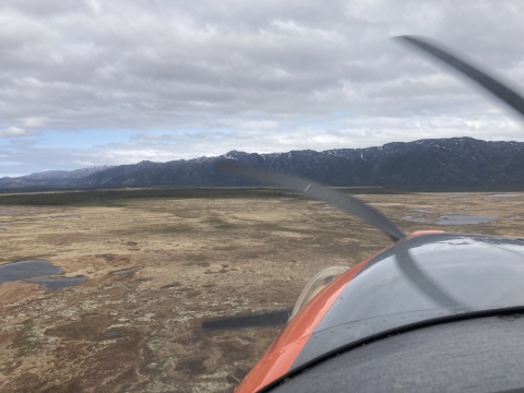 view of airplane propeller in motion flying over a landscape