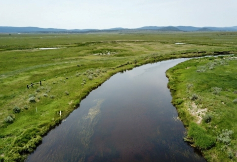 A river runs through a grassland. 