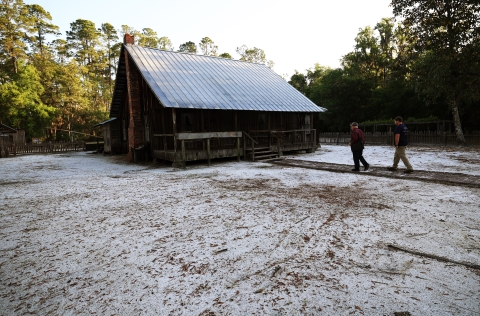 Joe Chesser, front, and his grandson Andrew stroll up the boardwalk to visit the Chesser family Homestead, where Joe grew up and is now part of the Okefenokee National Wildlife Refuge. The family kept the yard clear of vegetation to keep snakes visible and the house safe from fires. 