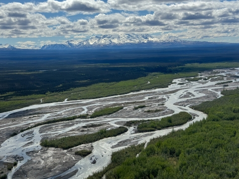 aerial view of river with mountains in the background