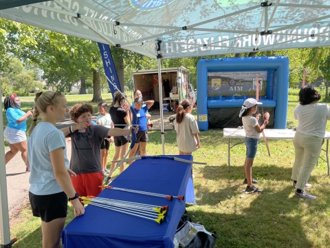 Youth participate in archery at the 2024 Cops and Bobbers fishing program as part of the Elizabeth Urban Wildlife Refuge Partnership