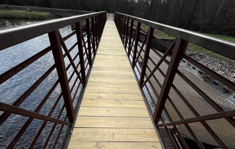 a completed metal bridge with a wooden platform