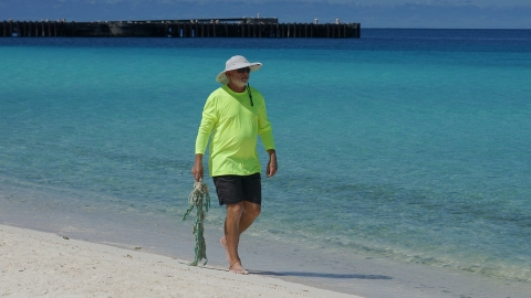 Wildlife biologist, Jon Plissner, walking on the beach at Midway Atoll