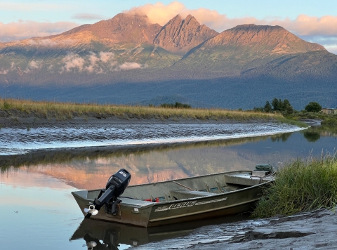 boat rests on the water with a mountain in the background