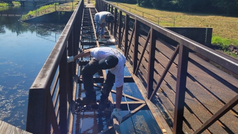 two people work on an narrow bridge