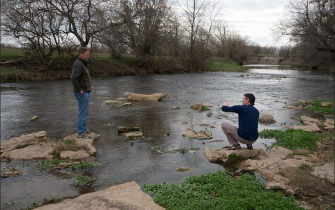 2 scientists having a discussion by a river