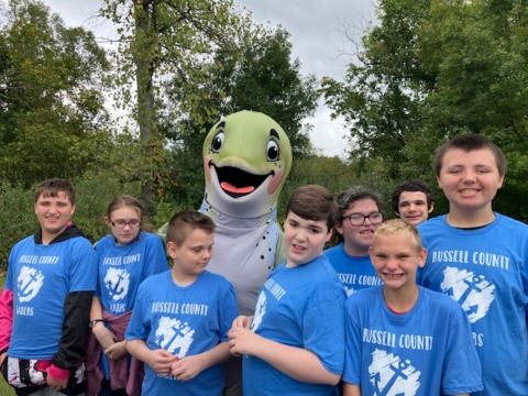 Group of kids smiling with fish mascot