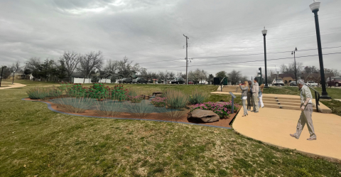 Digitally rendered image of a rain garden with visitors walking around