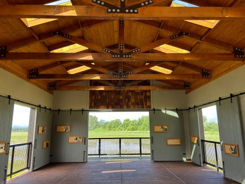 Interior of David B. Marshall Outdoor Classroom with sliding doors and a fence surrounding the building. Building overlooks Peregrine Marsh