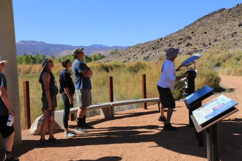 Visitors take turns using a scope to view ancient rock writing along the Black Canyon Trail at Pahranagat Refuge in Nevada.