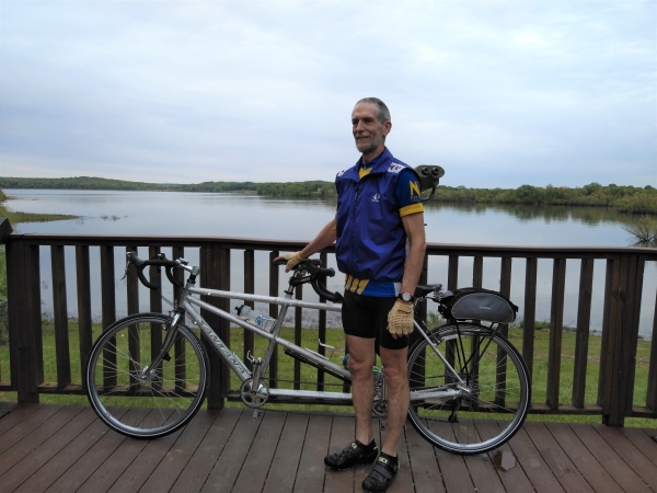 An image of a cyclist standing by their bike on an observation tower.