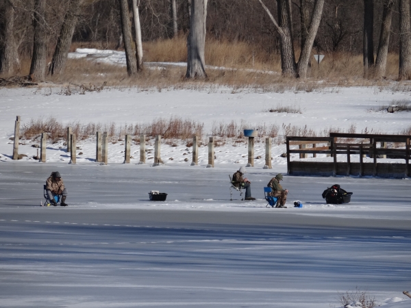 Three fisherman ice fishing on DeSoto Lake.