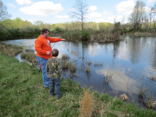 Father and son with small fish by Discovery Pond