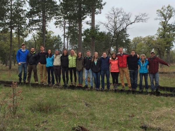 UW students pose on a fallen tree while hiking 