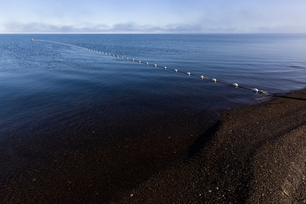 White floats on a subsistence net strung out from beach into the ocean.