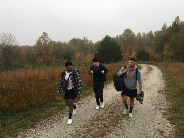 Three people walking on a gravel trail. 