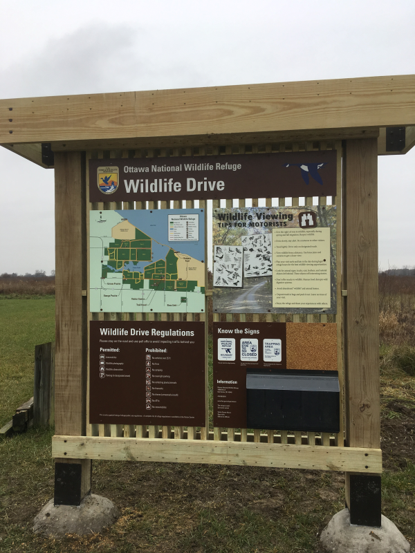 A wooden structure with signs the header reads Wildlife Drive