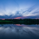 The sunset lights up the sky pink over the Carmans River