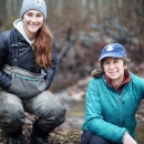 two women by a stream in the forest