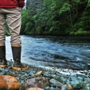 man standing by a river in rain gear