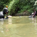 Two snorkelers in a river, heads above water, conversing