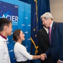 a young man and woman meet an older man at an event