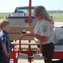 a woman wearing a service uniform shows a turtle to a small boy