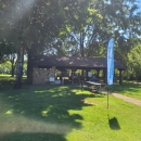 Park picnic area in a grassy meadow with lush green trees and a national fish hatchery banner