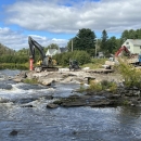 Construction equipment working on the side of a flowing river