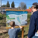 An adult and child read a sign at Wapato Lake National Wildlife Refuge.