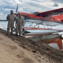 two people standing in front of an airplane