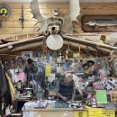 person working in an office with pelts and antlers and outdoor items all around